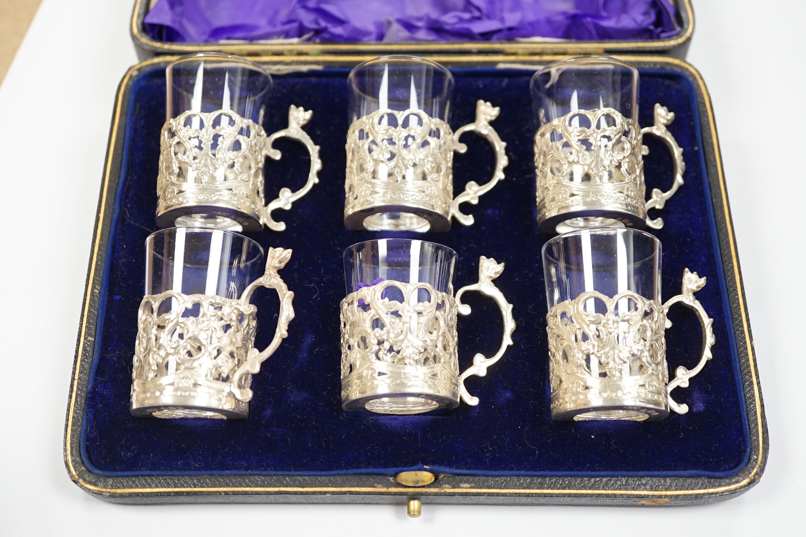 A George III engraved silver helmet shaped cream jug, Francis Purton?, London, circa 1790, height 10.6cm (a.f.), together with a cased set of six George V silver coffee can holders, with glass inserts, Marples & Co, Birm